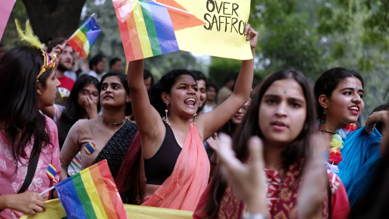 Protestors holding rainbow flags and signs