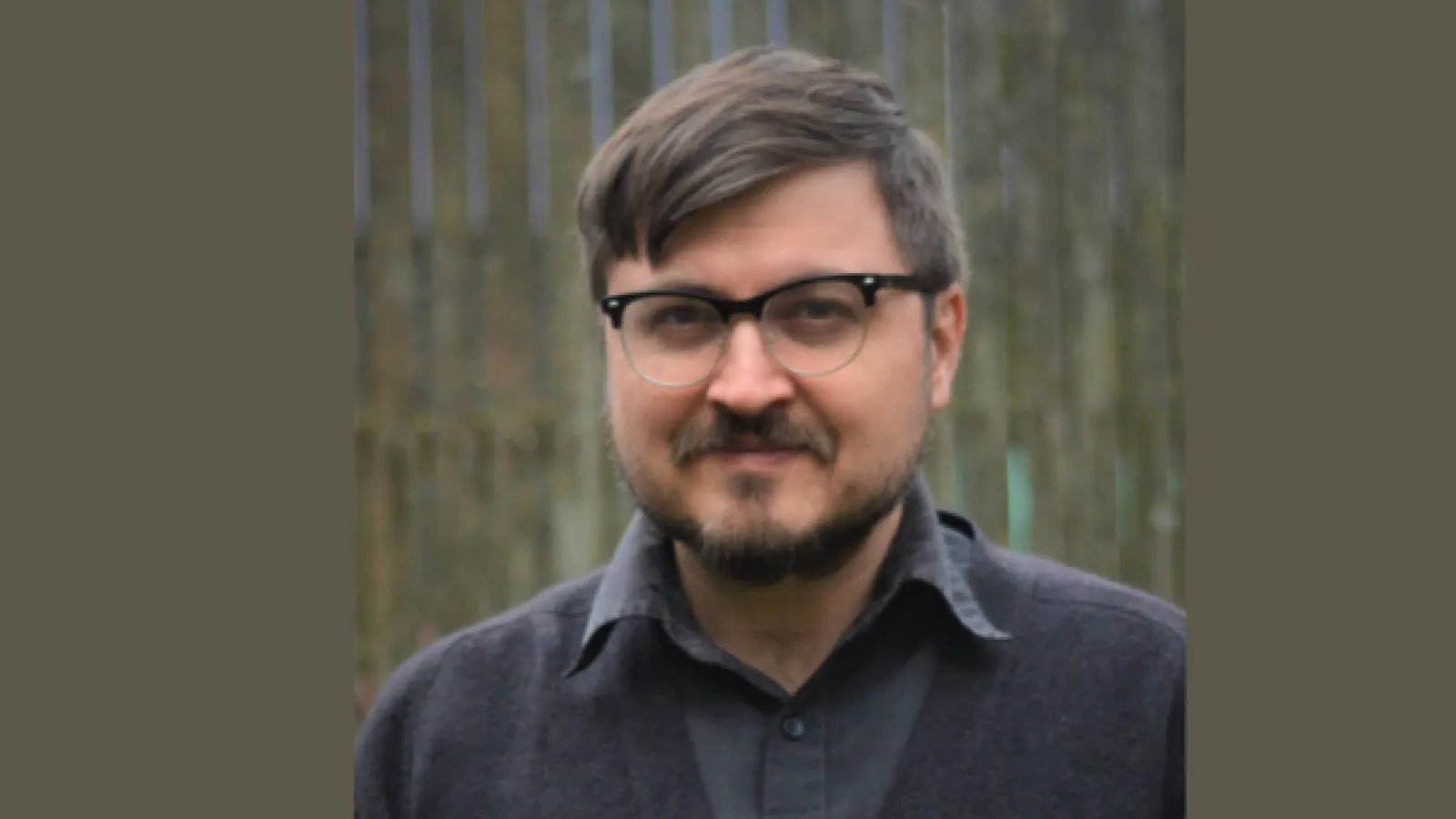 Headshot of Darren Byler, he has brown hair, glasses and a brown beard. 
