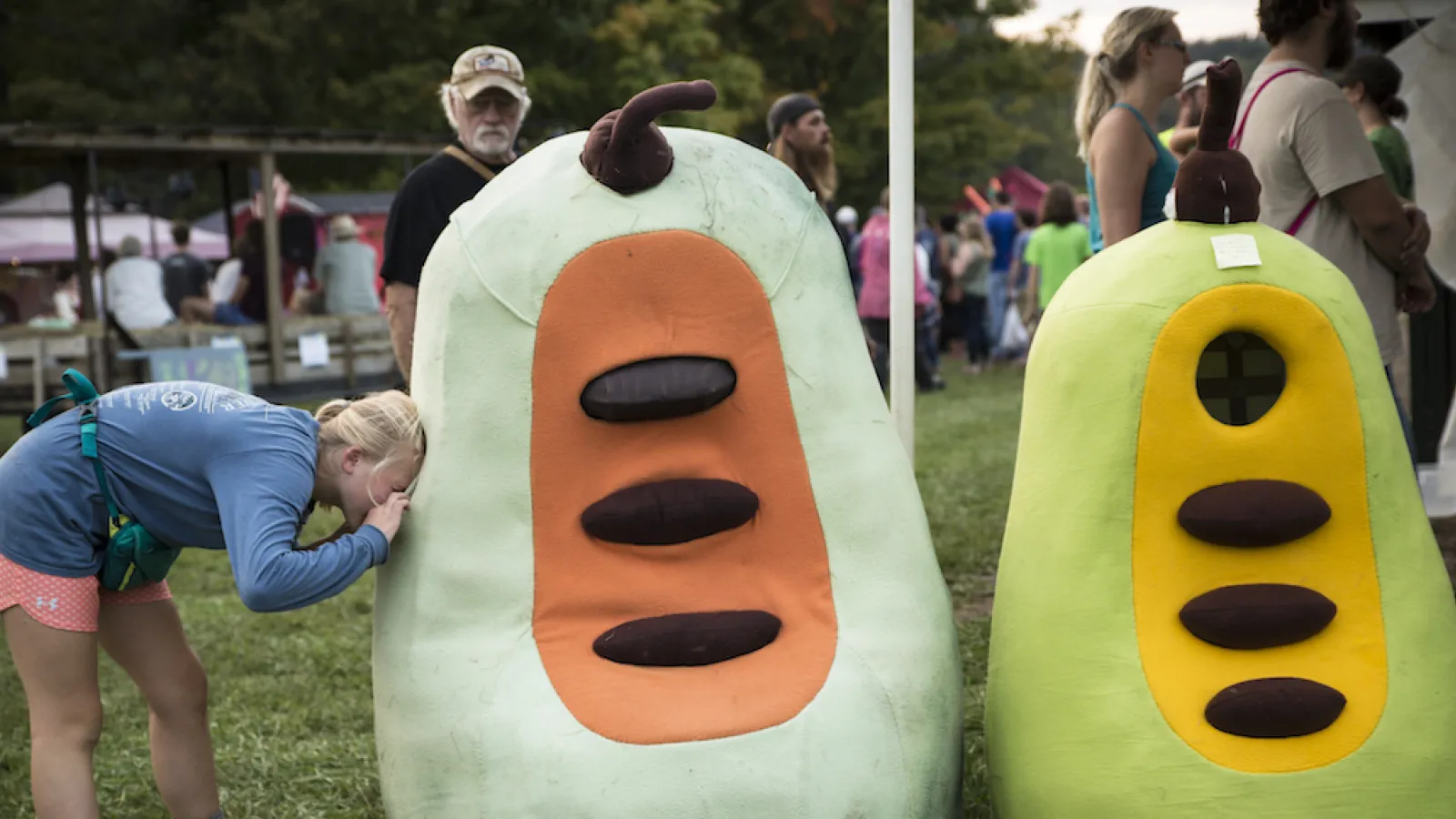 A person peering into a giant paw paw costume