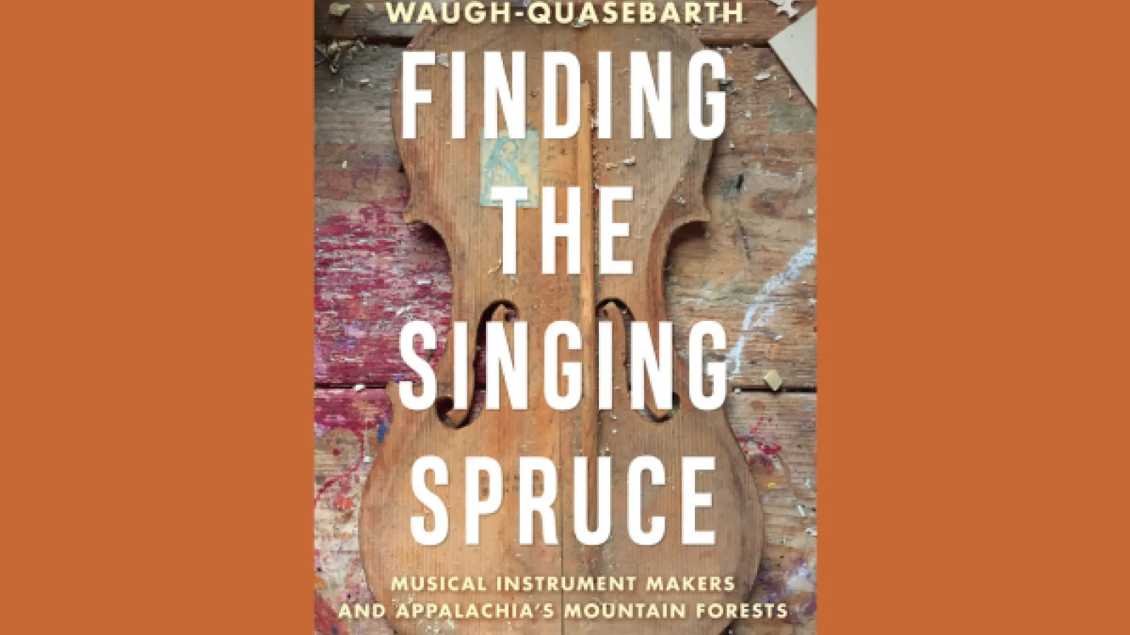Finding the Singing Spruce Book title with a violin behind it