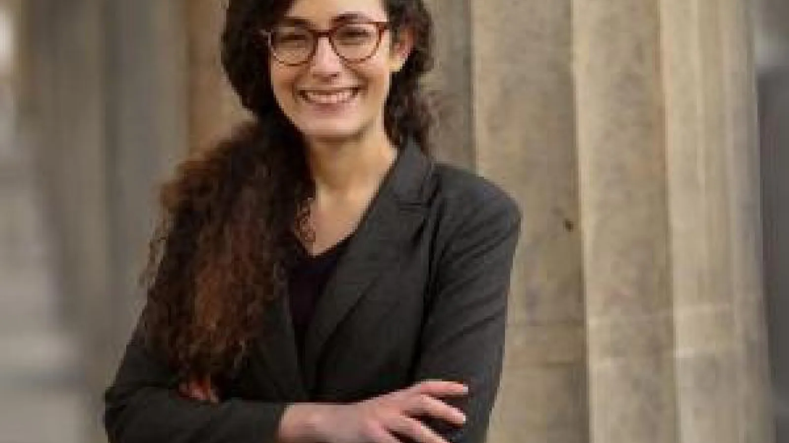 Professor smiling with arms crossed