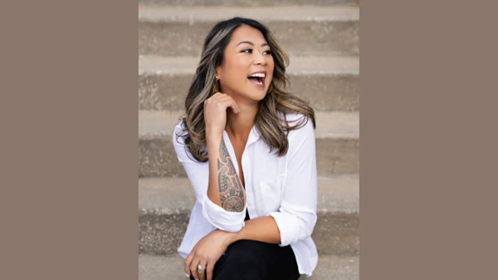 Stacey Litam sitting on steps and laughing