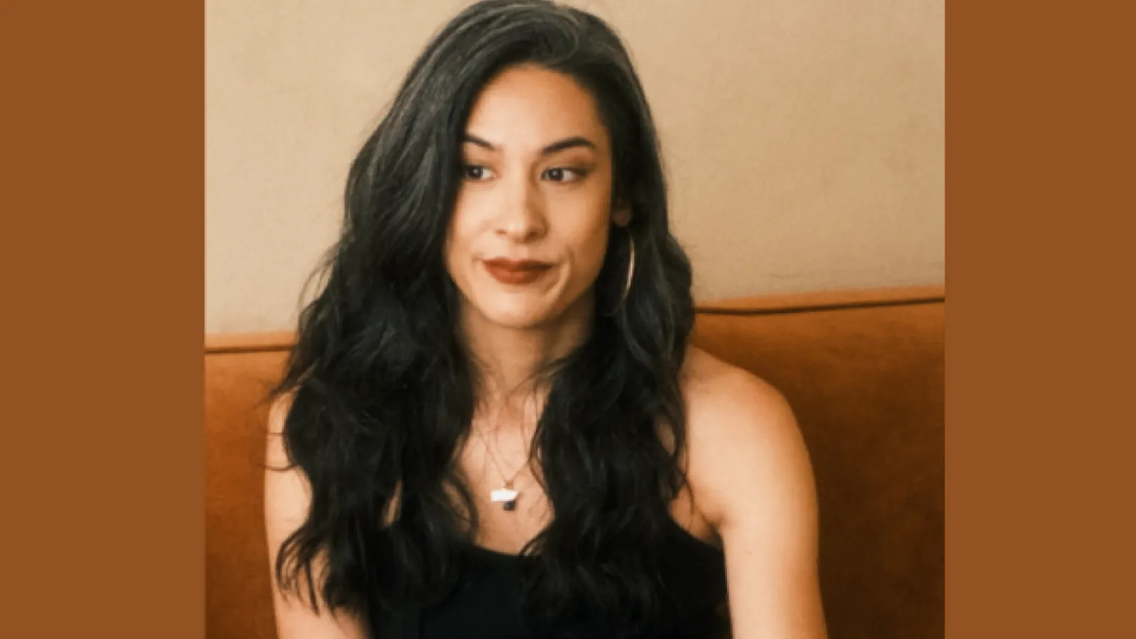 Author Stephanie Ginsese sitting and smiling with long dark hair