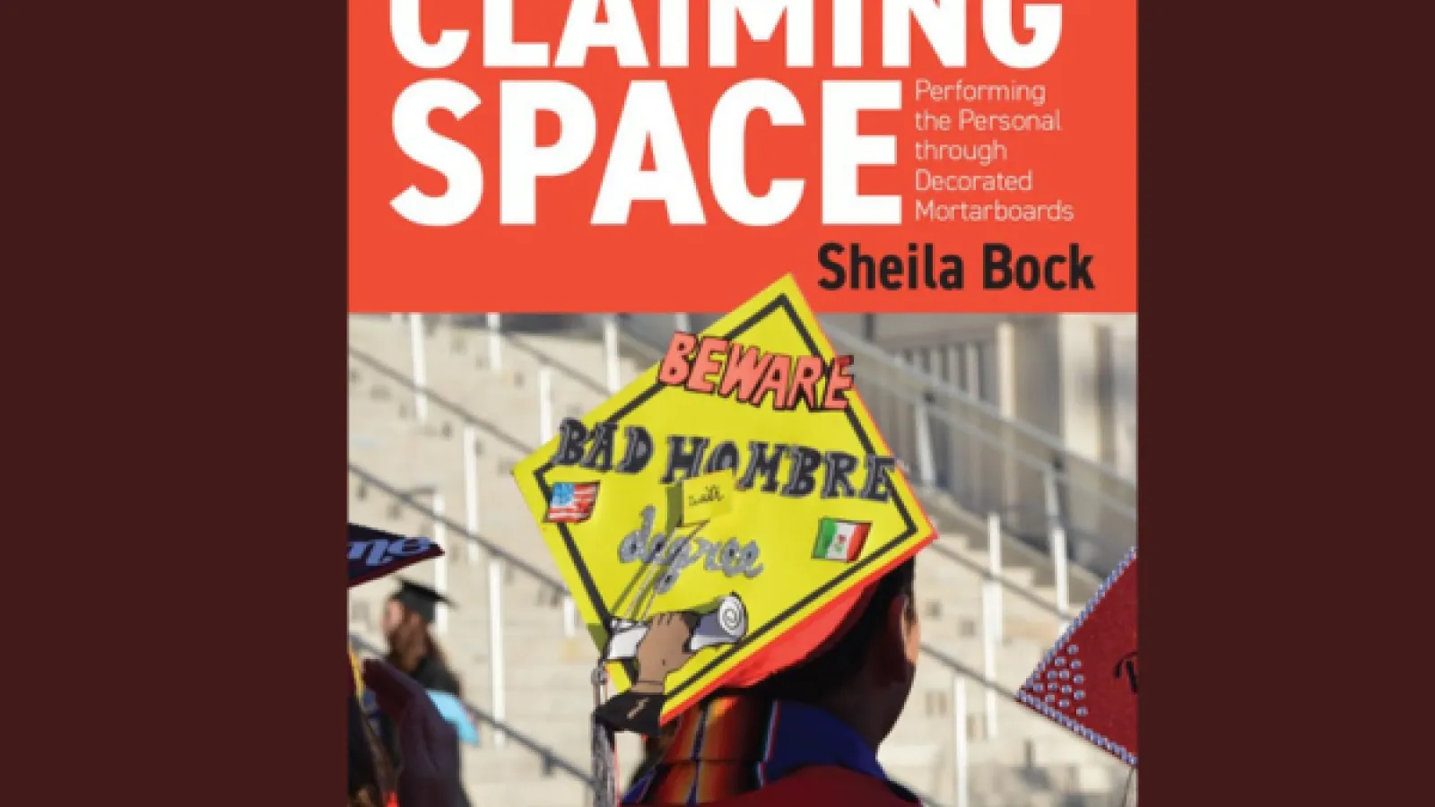 A decorated graduation cap with the title "Claiming Space" in bold font
