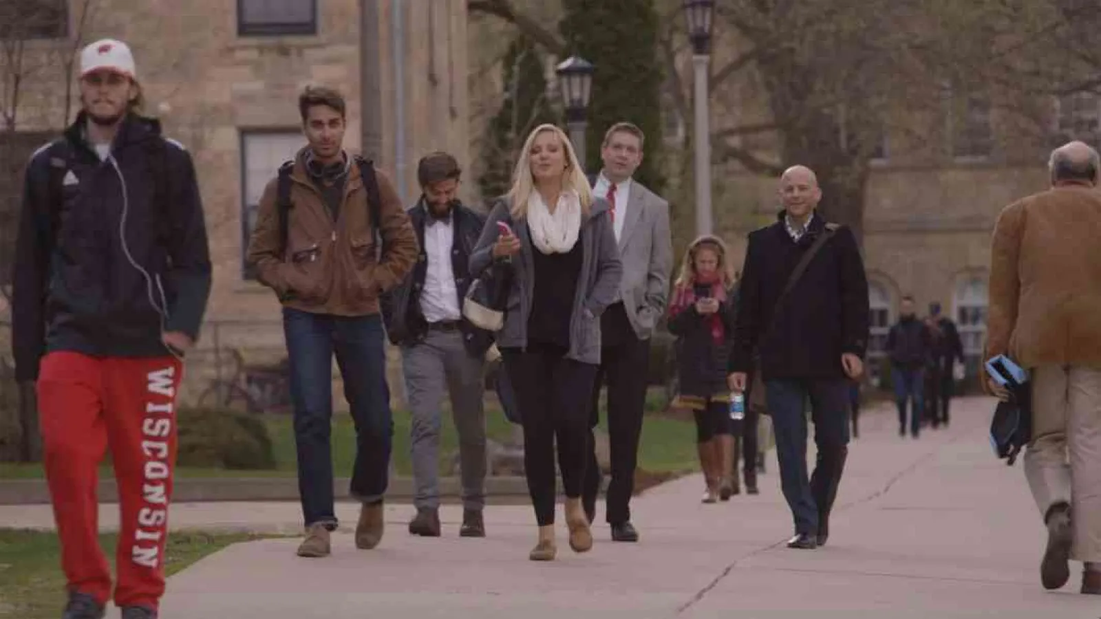 A group of people walking on a college campus