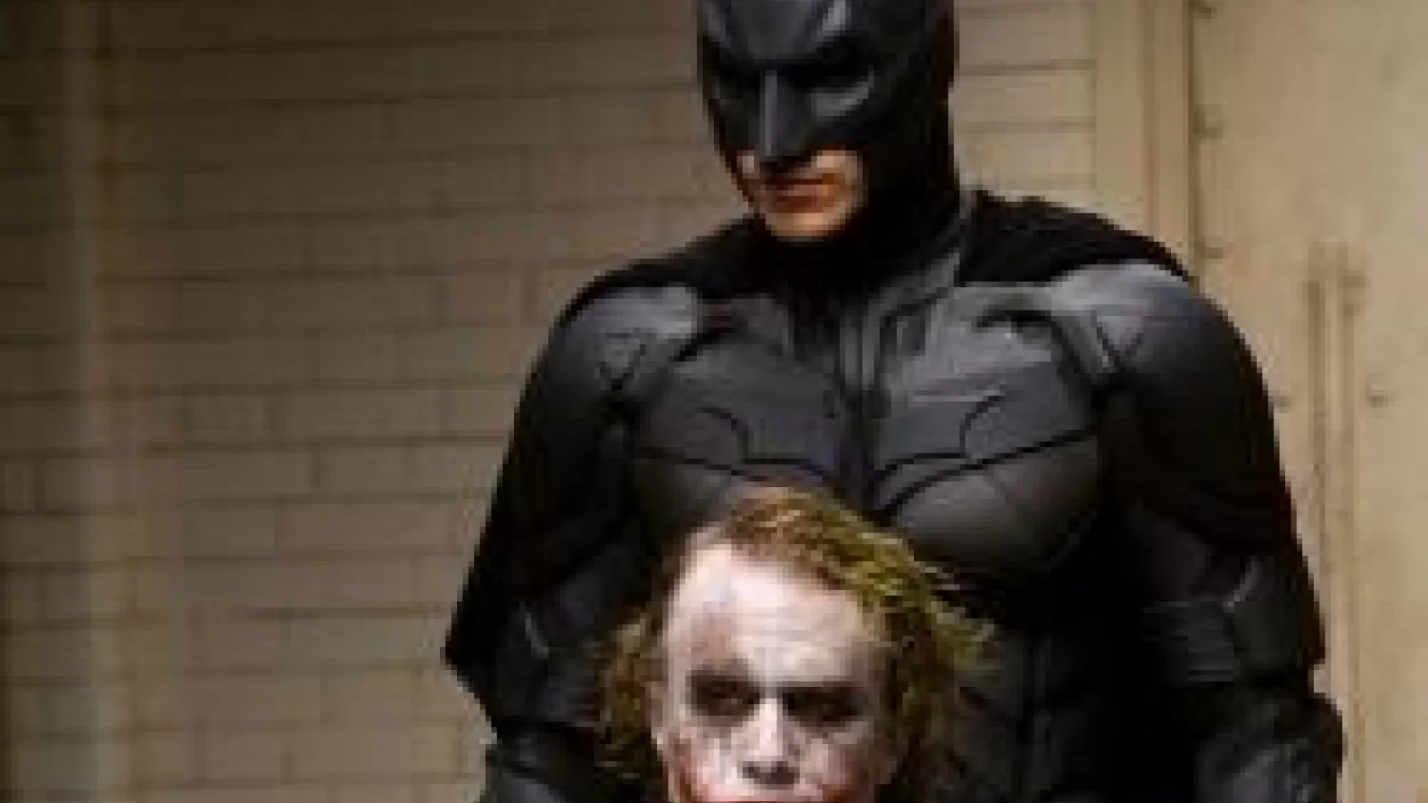 Image from a batman movie with batman standing behind joker