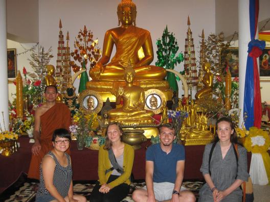 Faculty and Students pose in front of statue