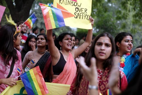 Protestors holding rainbow flags and signs