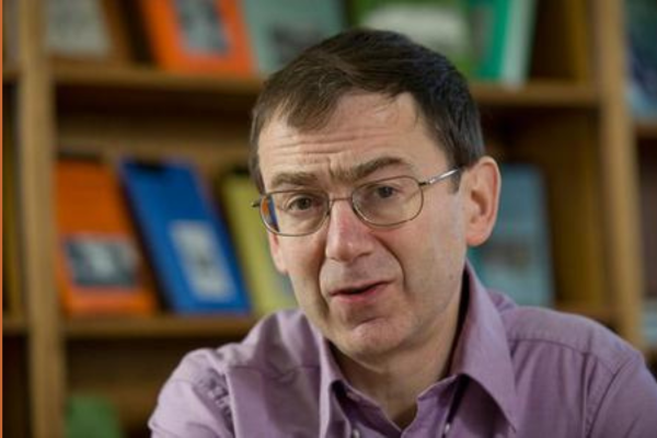 Profile picture of a man with brown hair, glasses and a lavender shirt