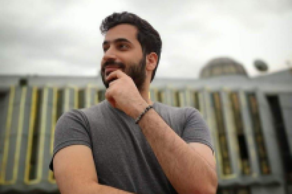 A Palestinian Man smiling and wearing a tshirt