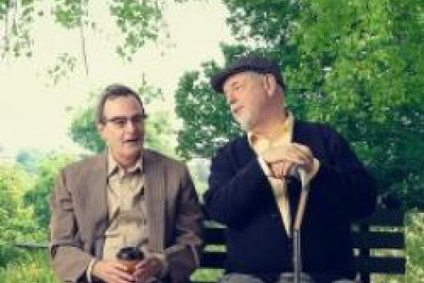 two men sitting on a bench