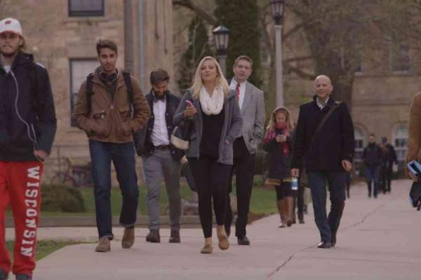A group of people walking on a college campus